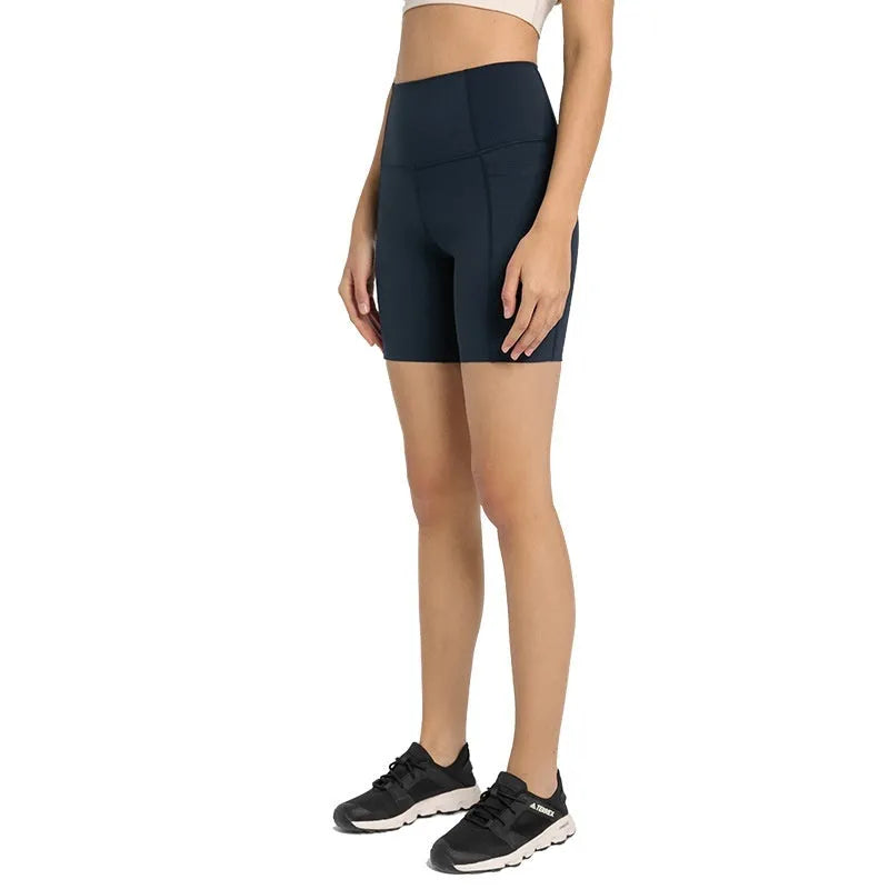 Women's tight-fit cotton blend sports shorts in short fifth pants length on a neutral background.