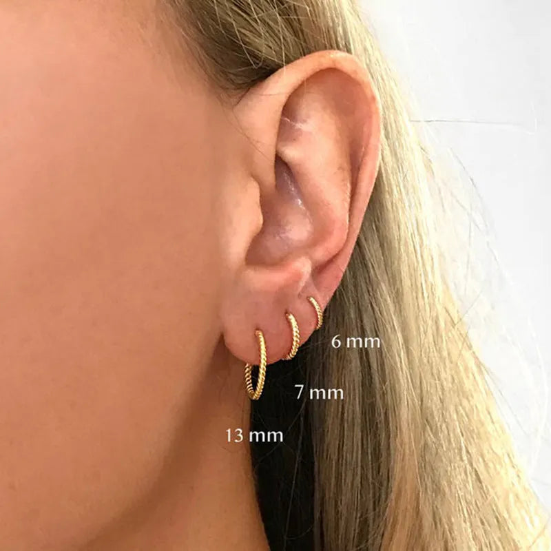 Close-up of S925 sterling silver twisted string round hoop earrings in gold finish.