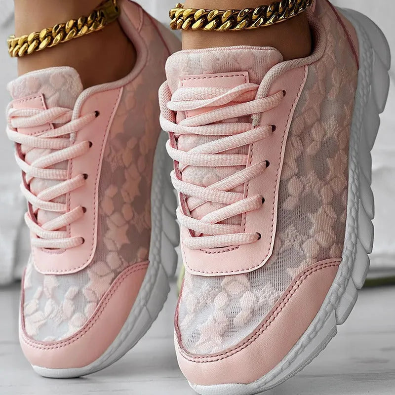Women's white canvas running shoes with flat heel and round toe, showing sports style and lace-up design