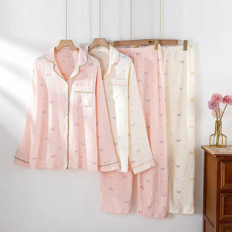 Women's pink cotton crepe pajama suit with long sleeves and trousers laid flat.