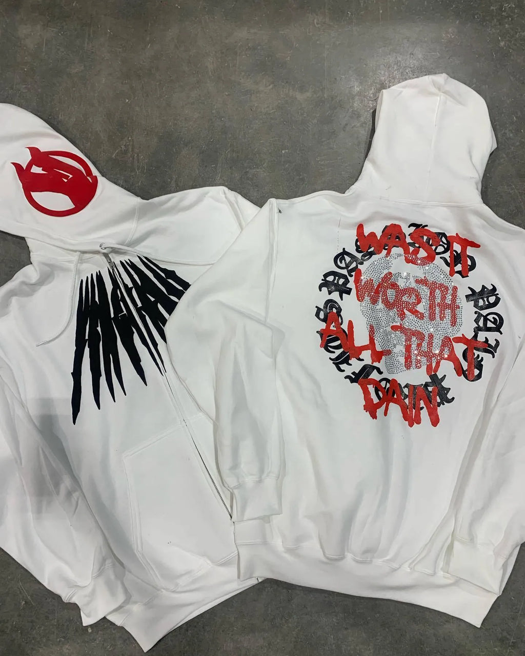 Black loose hooded sweatshirt with white skull print and rhinestone details, worn open as a cardigan.