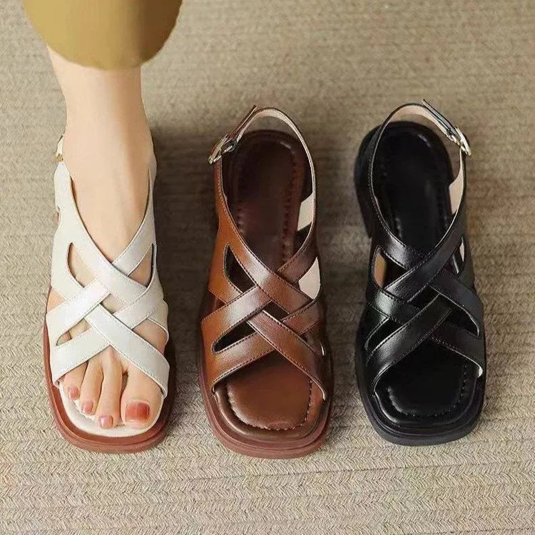 Women's glossy black patent leather beach sandals with square toe and cross-band strap.