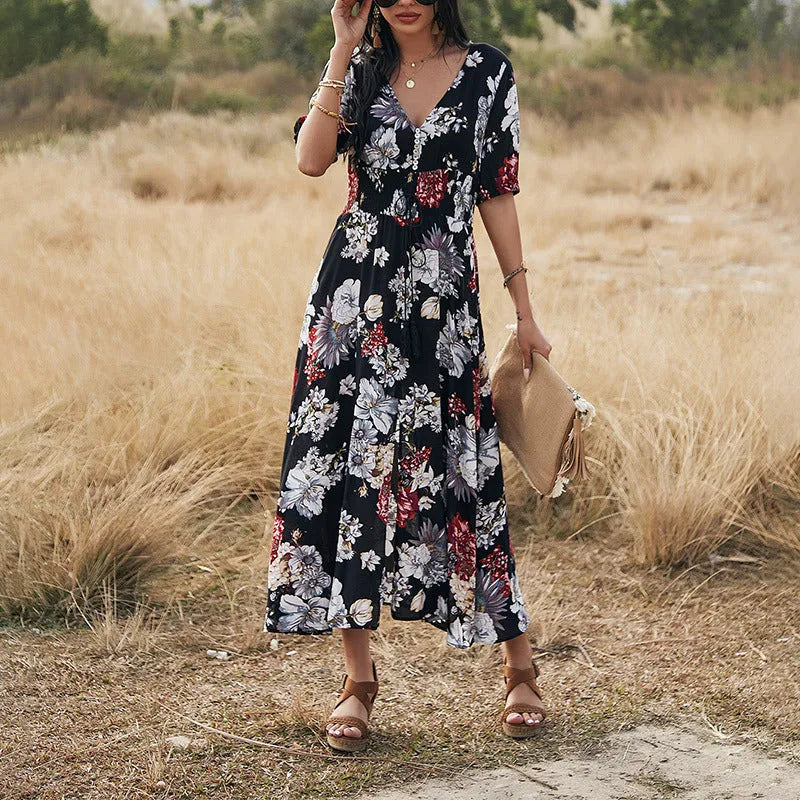 Yellow floral print women's dress with V-neck, short sleeves, elastic high waist, and a full mid-length skirt.