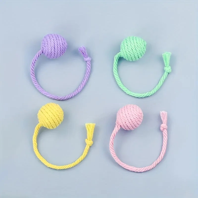 Cat toy ball with attached rope and bell in green, pink, purple or yellow colours showing 6cm and 3cm size comparison