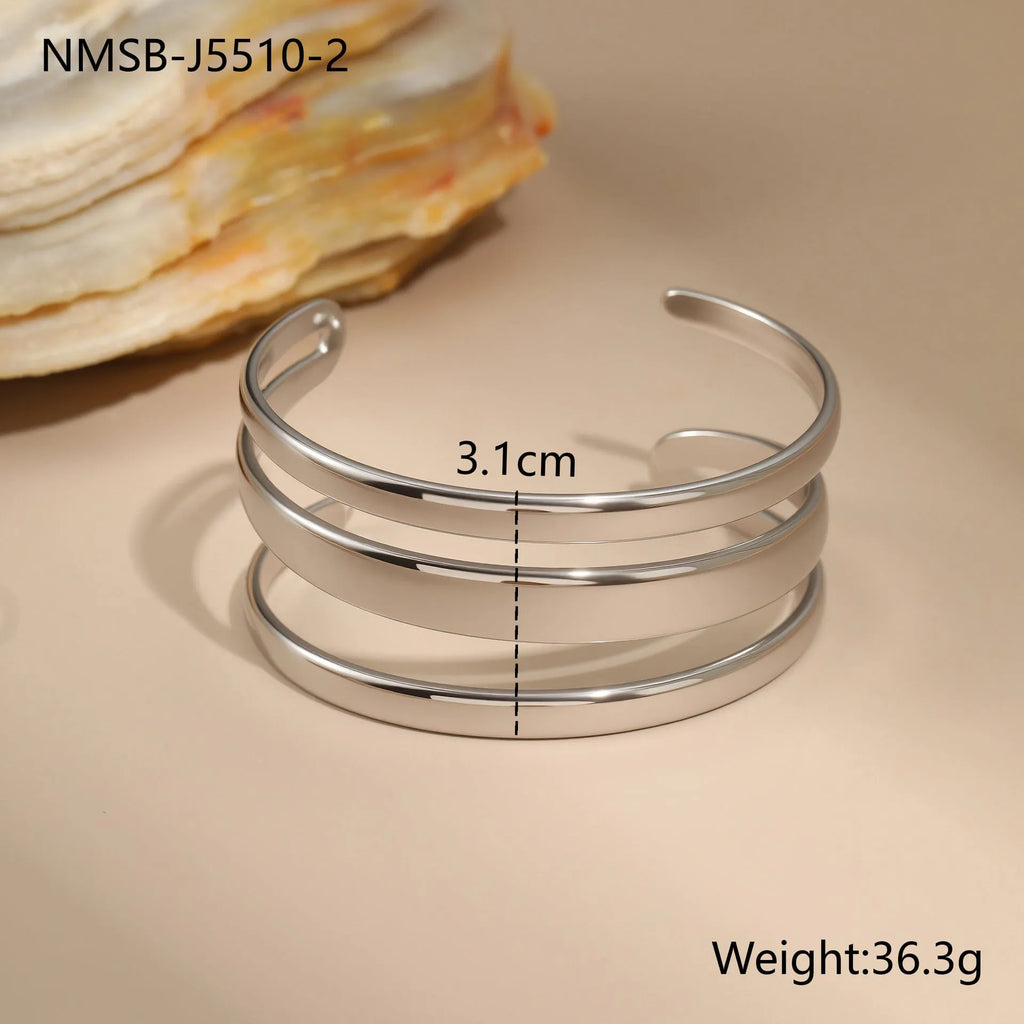 Stainless steel women's bracelet with geometric line design, shown in gold and steel finish options