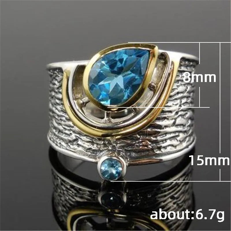 Close-up of a women's blue zircon alloy ring with a drop shape and Chinese-inspired design on a hand.