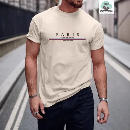 Man wearing a loose fit apricot coloured short-sleeved T-shirt with a black letter print on the front.