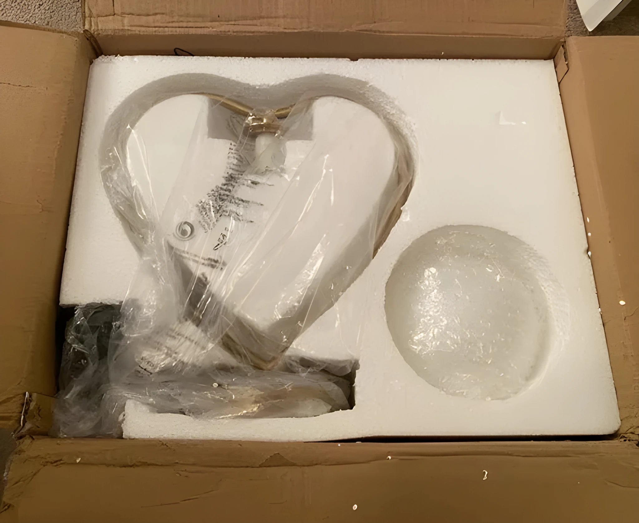Small white heart shaped table lamp with a touch sensor base and glowing warm light.