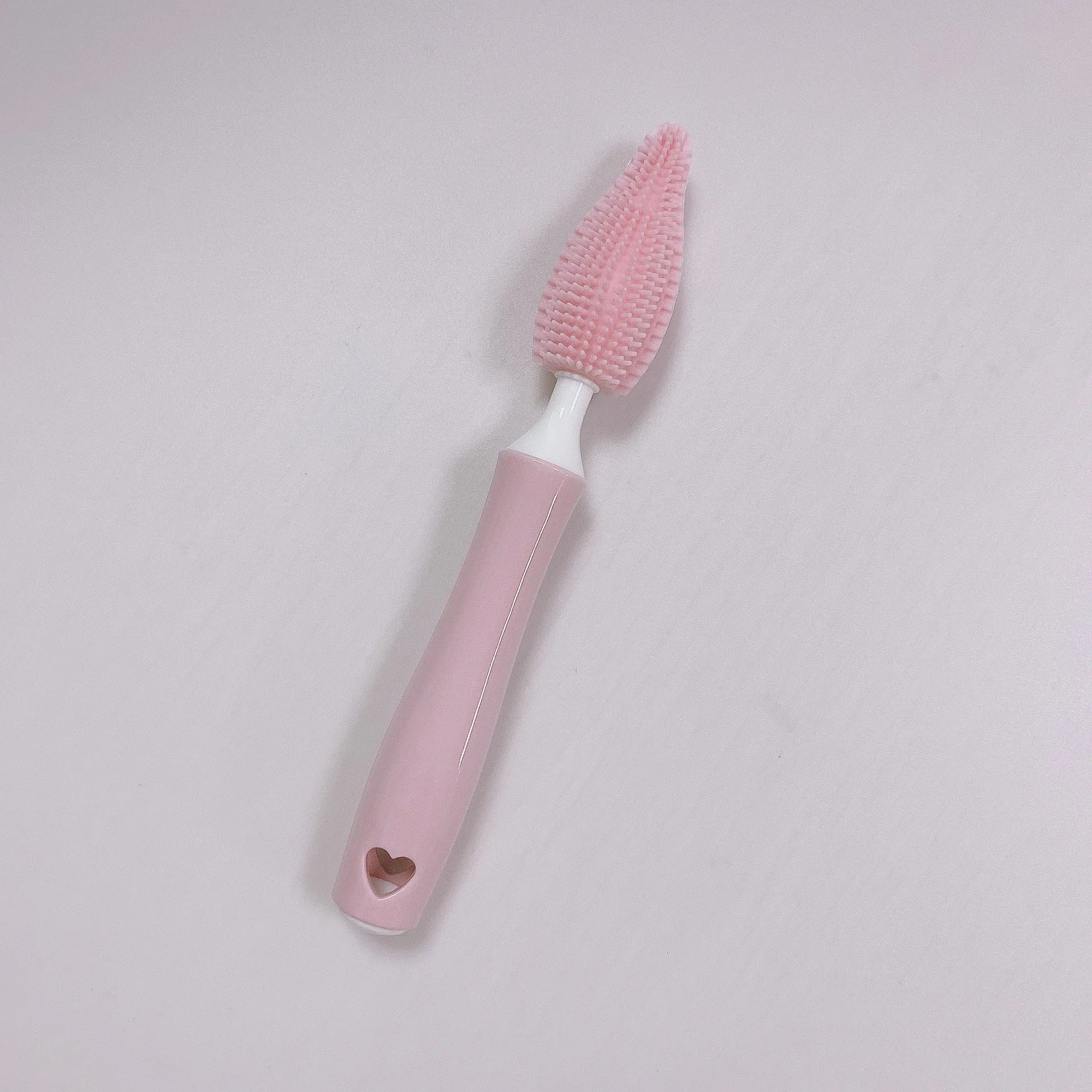 Silicone baby bottle cleaning brush and separate straw cleaner in pink, blue, and yellow colours.