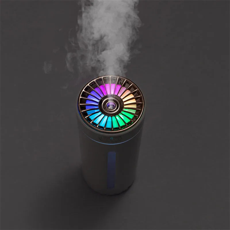 Black and white portable USB rechargeable humidifier with colourful LED lights on a car cup holder.