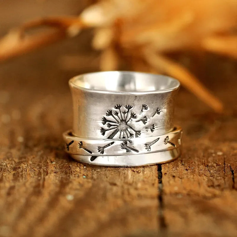 Silver rotatable floral fashion ring showing adjustable flower element on band