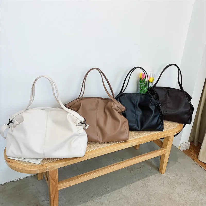 Large soft surface messenger bag showing horizontal square shape with adjustable shoulder strap and zip opening