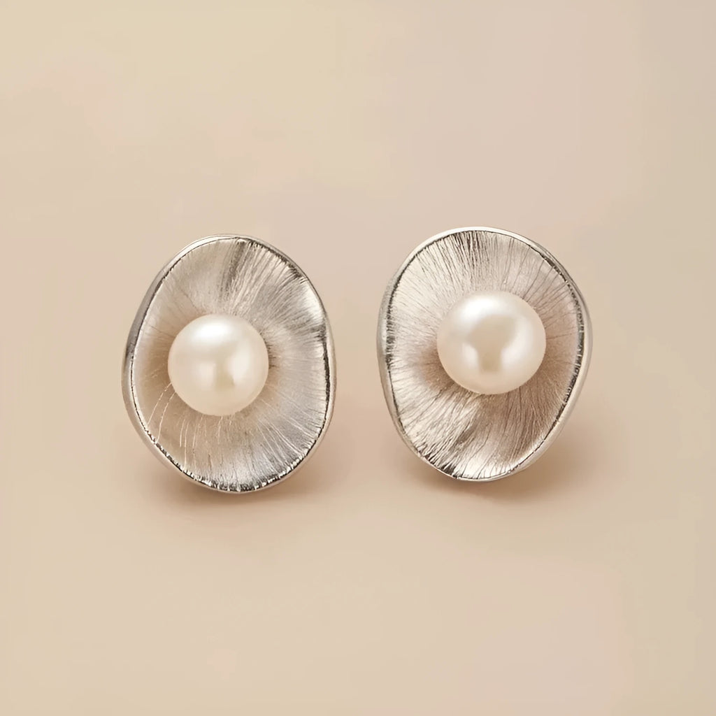 Pearl sterling silver needle earrings with geometric design elements in gold colour