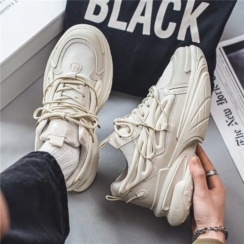 Men's beige and black low-top lace-up sneakers with mesh upper and rubber platform sole.